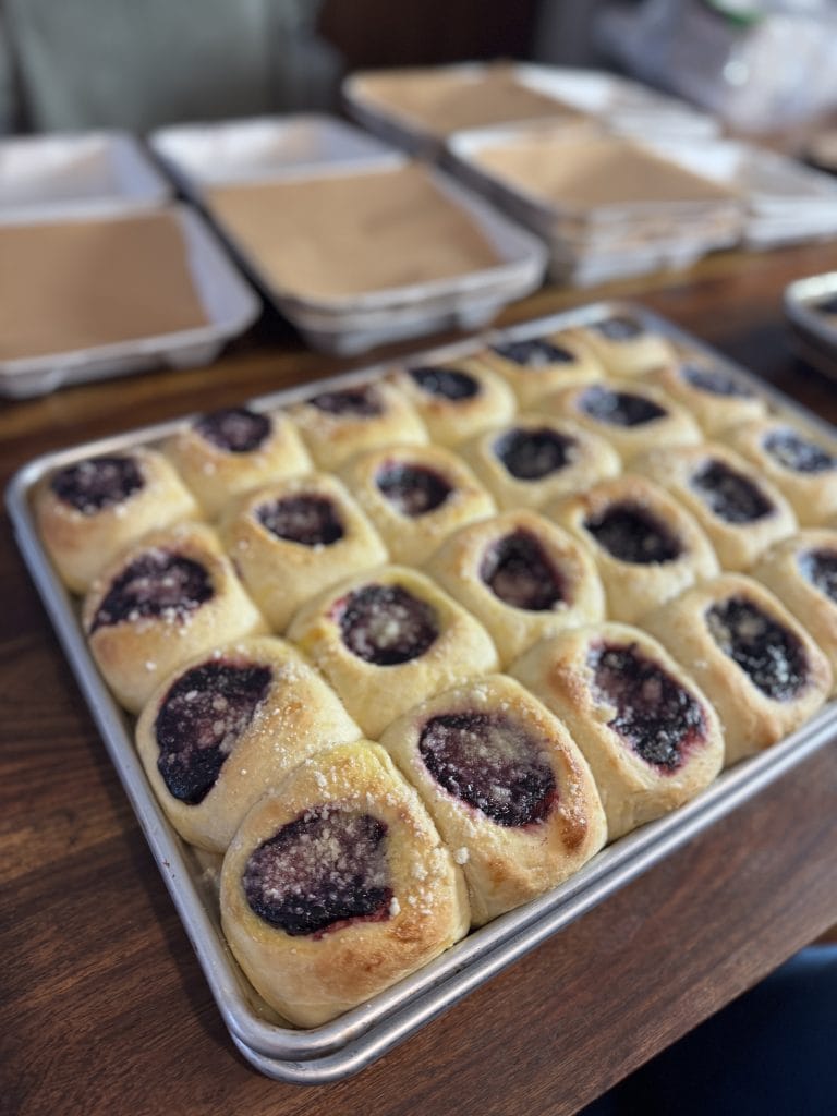 berry kolaches in a half sheet pan on a wood table